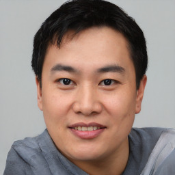 Joyful asian young-adult male with short  black hair and brown eyes