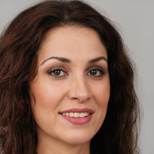 Joyful white young-adult female with long  brown hair and brown eyes