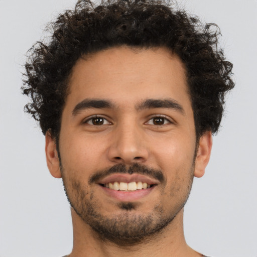 Joyful latino young-adult male with short  brown hair and brown eyes