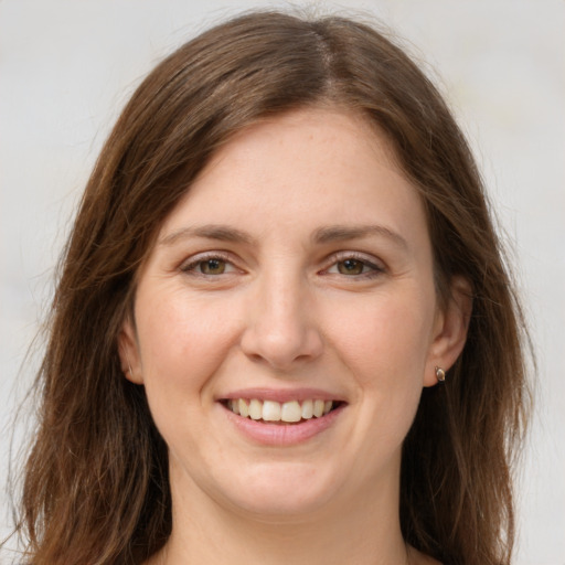 Joyful white young-adult female with long  brown hair and green eyes