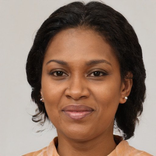 Joyful black adult female with medium  brown hair and brown eyes