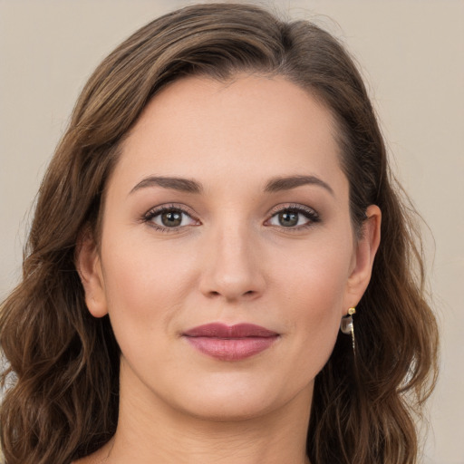 Joyful white young-adult female with long  brown hair and green eyes