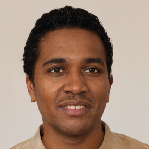 Joyful black young-adult male with short  black hair and brown eyes