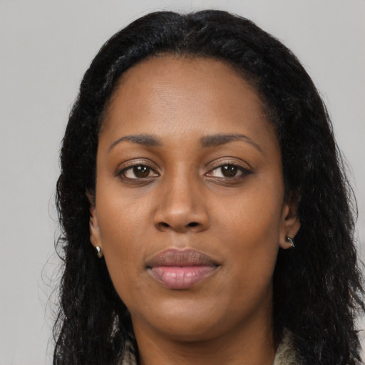 Joyful black young-adult female with long  black hair and brown eyes
