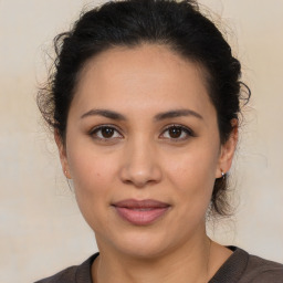 Joyful latino young-adult female with medium  brown hair and brown eyes