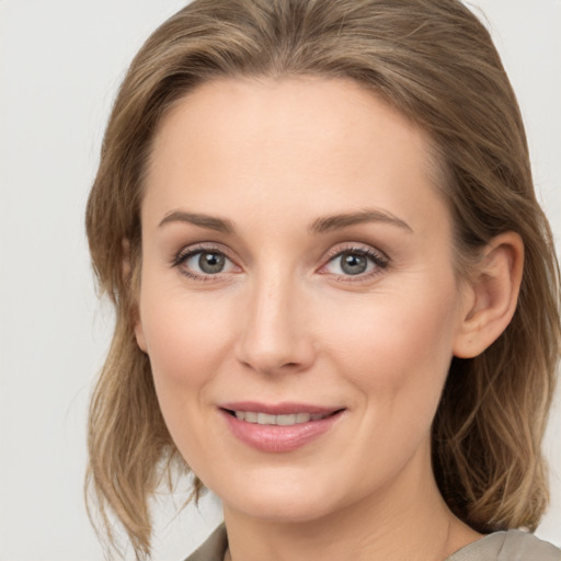 Joyful white young-adult female with medium  brown hair and grey eyes