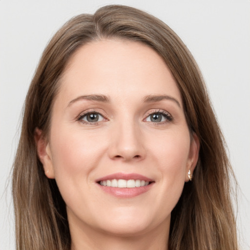 Joyful white young-adult female with long  brown hair and grey eyes