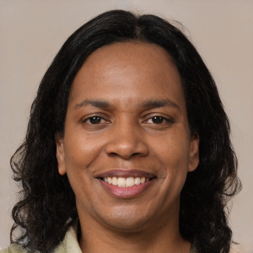 Joyful black young-adult female with long  black hair and brown eyes