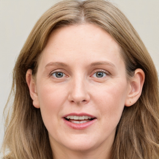 Joyful white adult female with long  brown hair and blue eyes