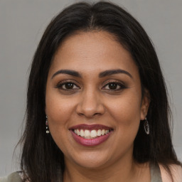 Joyful latino young-adult female with long  brown hair and brown eyes