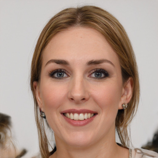 Joyful white young-adult female with medium  brown hair and grey eyes