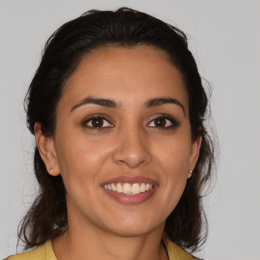 Joyful latino young-adult female with medium  brown hair and brown eyes