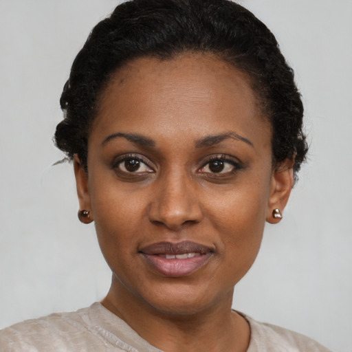 Joyful black young-adult female with short  black hair and brown eyes