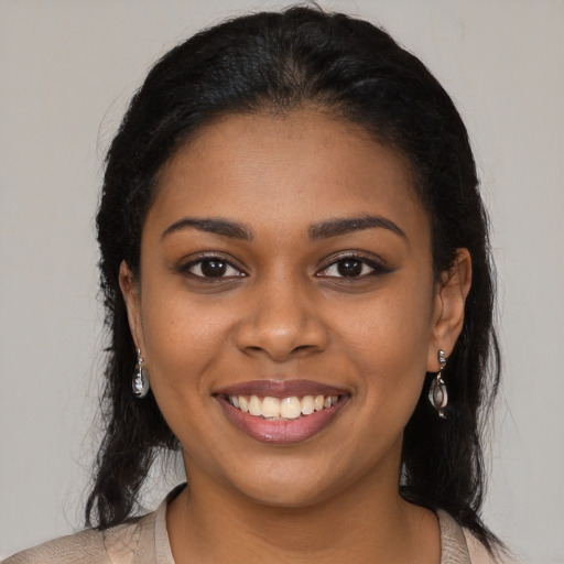 Joyful black young-adult female with long  brown hair and brown eyes