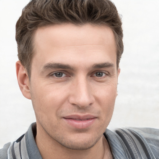 Joyful white young-adult male with short  brown hair and grey eyes