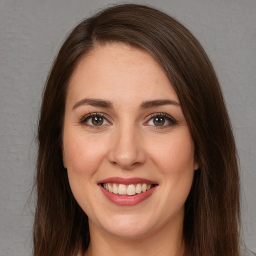 Joyful white young-adult female with long  brown hair and brown eyes