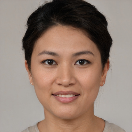 Joyful asian young-adult female with short  brown hair and brown eyes