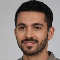 Joyful white young-adult male with short  black hair and brown eyes