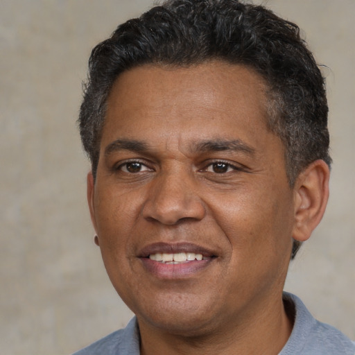 Joyful black adult male with short  black hair and brown eyes