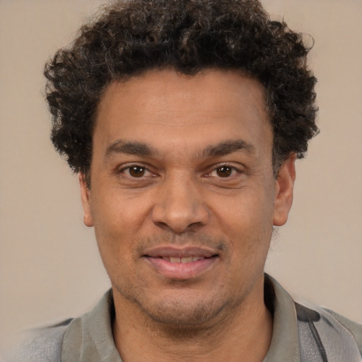 Joyful latino adult male with short  brown hair and brown eyes