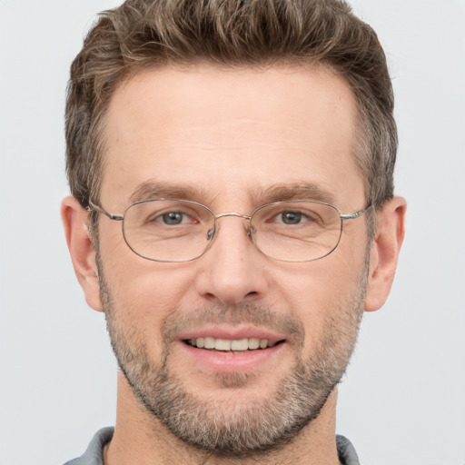 Joyful white adult male with short  brown hair and grey eyes