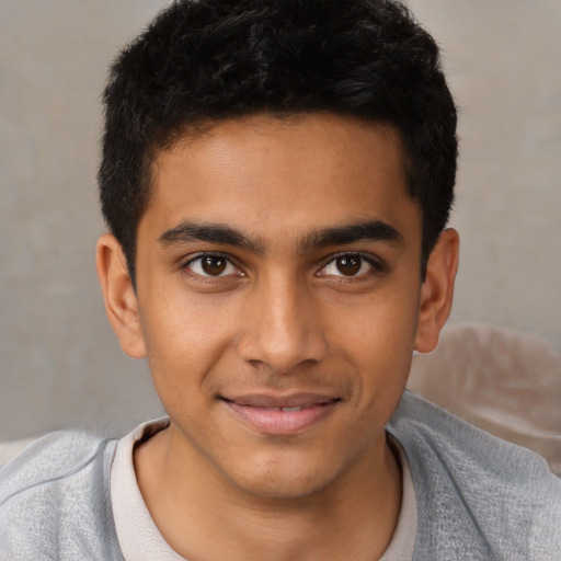 Joyful latino young-adult male with short  black hair and brown eyes