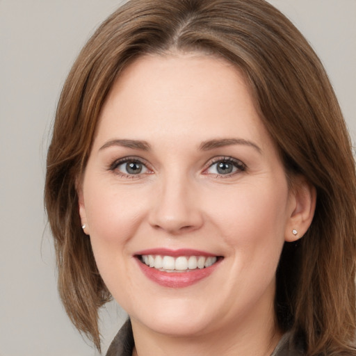 Joyful white young-adult female with medium  brown hair and grey eyes