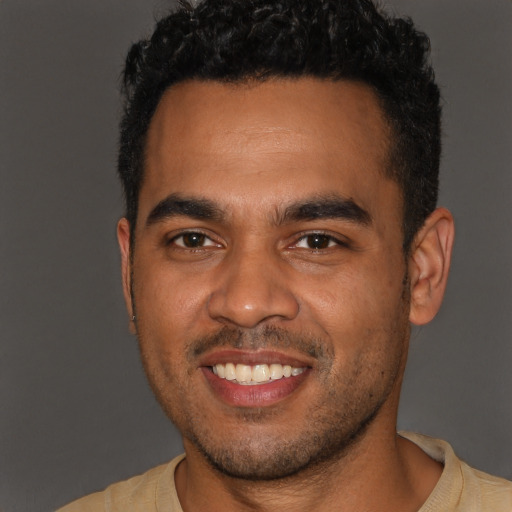 Joyful black young-adult male with short  brown hair and brown eyes