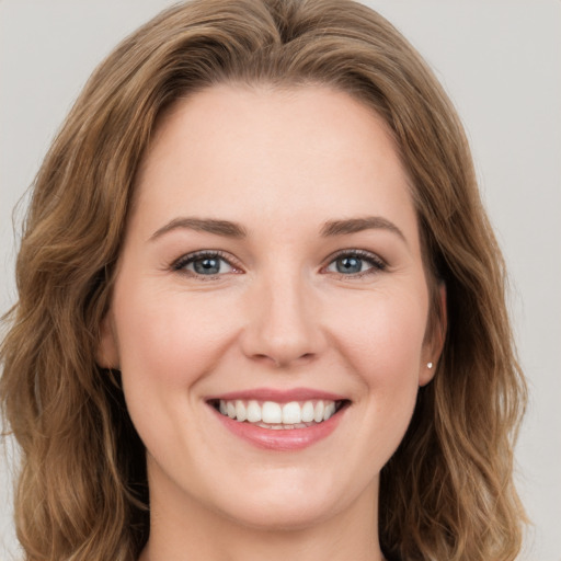 Joyful white young-adult female with long  brown hair and green eyes