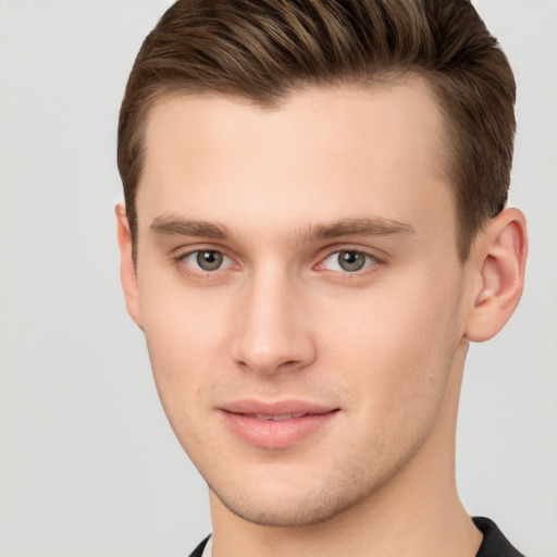 Joyful white young-adult male with short  brown hair and grey eyes