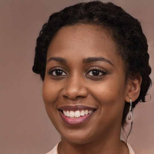 Joyful black young-adult female with long  brown hair and brown eyes