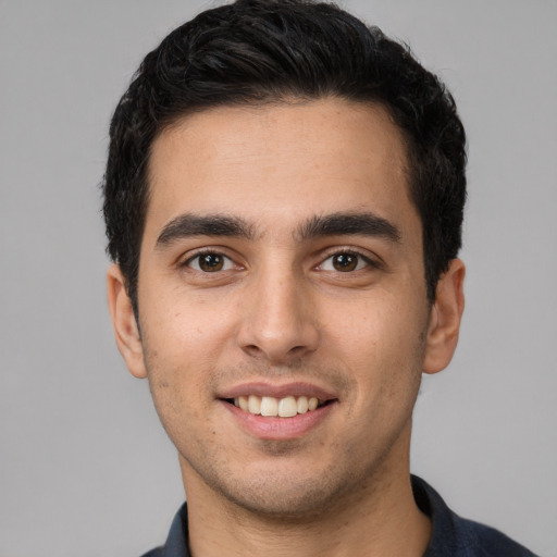 Joyful white young-adult male with short  black hair and brown eyes