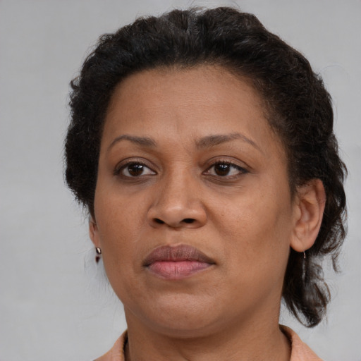 Joyful black adult female with short  brown hair and brown eyes
