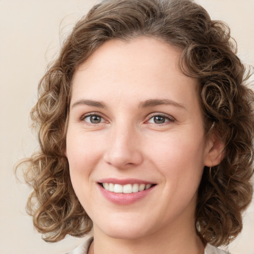 Joyful white young-adult female with medium  brown hair and green eyes