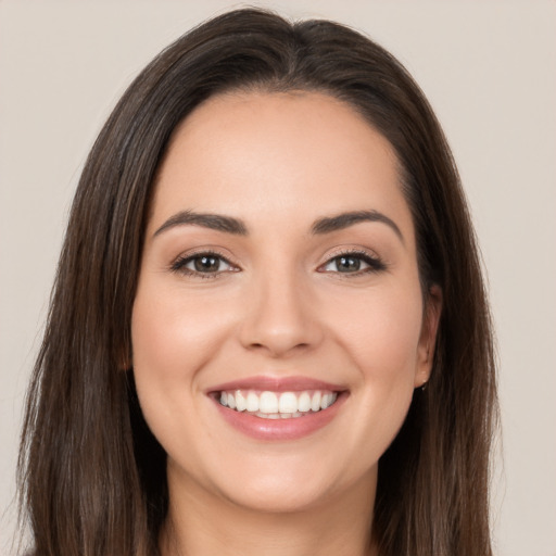 Joyful white young-adult female with long  brown hair and brown eyes