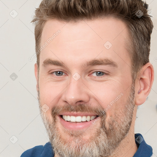 Joyful white adult male with short  brown hair and grey eyes