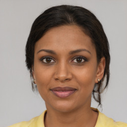 Joyful black young-adult female with medium  brown hair and brown eyes