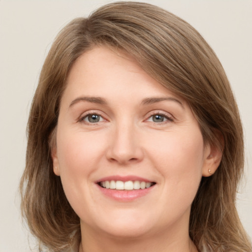 Joyful white young-adult female with medium  brown hair and grey eyes