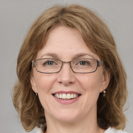 Joyful white adult female with medium  brown hair and blue eyes