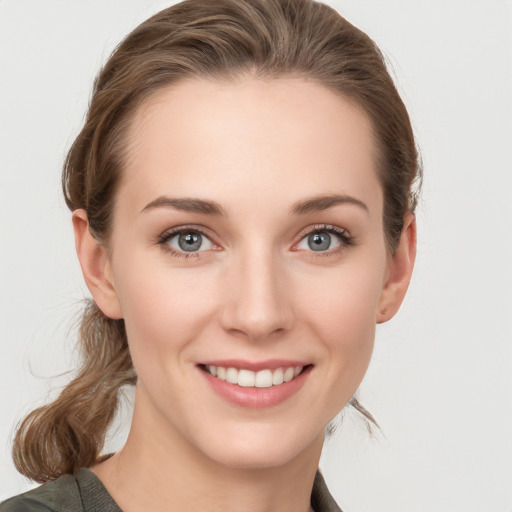 Joyful white young-adult female with medium  brown hair and grey eyes