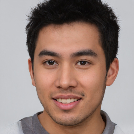 Joyful asian young-adult male with short  brown hair and brown eyes