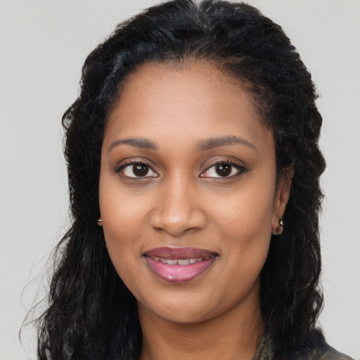 Joyful black young-adult female with long  brown hair and brown eyes