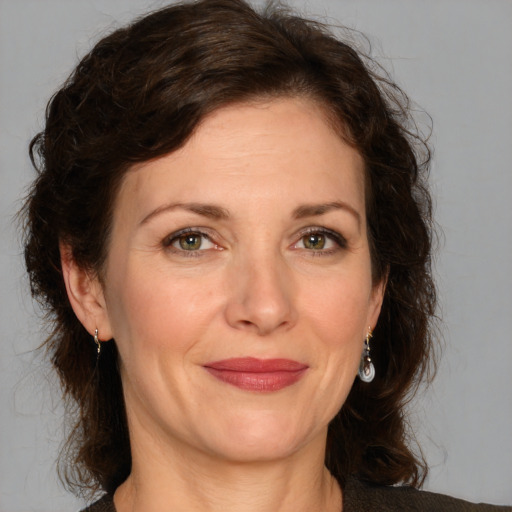 Joyful white adult female with medium  brown hair and green eyes