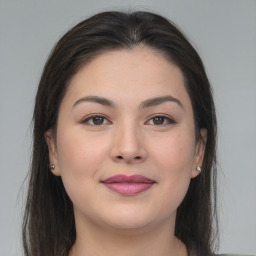 Joyful asian young-adult female with long  brown hair and brown eyes