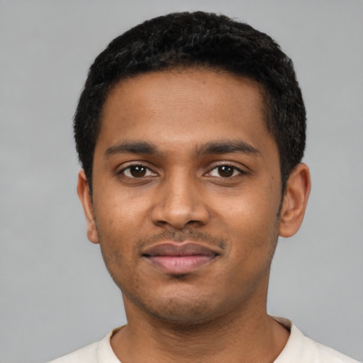 Joyful black young-adult male with short  black hair and brown eyes