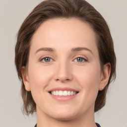 Joyful white young-adult female with medium  brown hair and green eyes