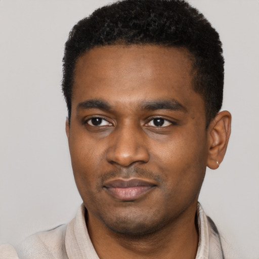 Joyful black young-adult male with short  black hair and brown eyes