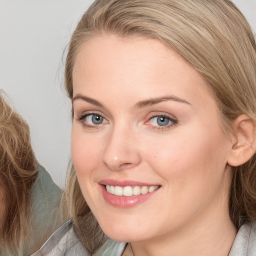 Joyful white young-adult female with medium  brown hair and blue eyes