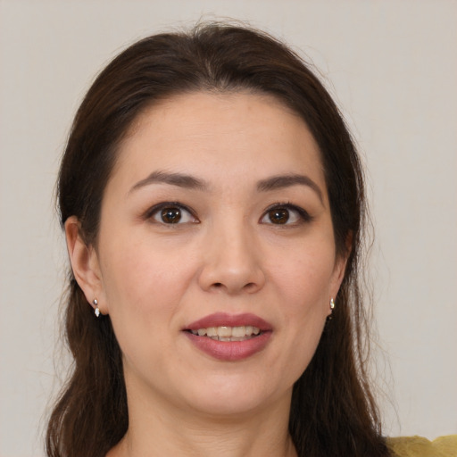 Joyful white young-adult female with long  brown hair and brown eyes