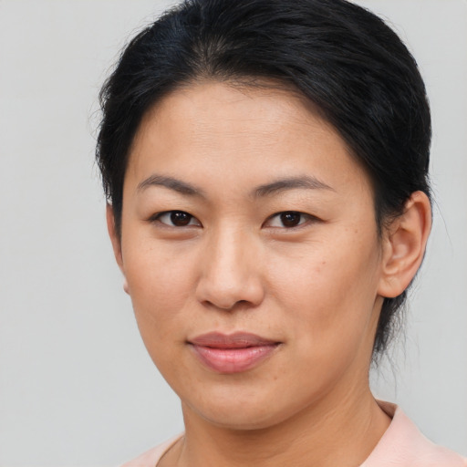 Joyful asian young-adult female with short  brown hair and brown eyes